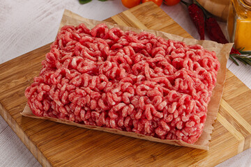 Raw minced beef meat over board