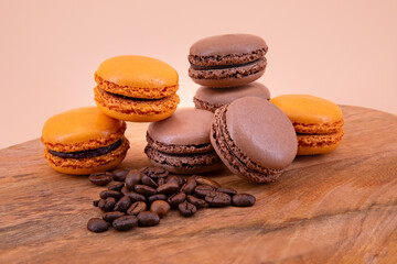 Brown and orange french macaroons on a wooden board