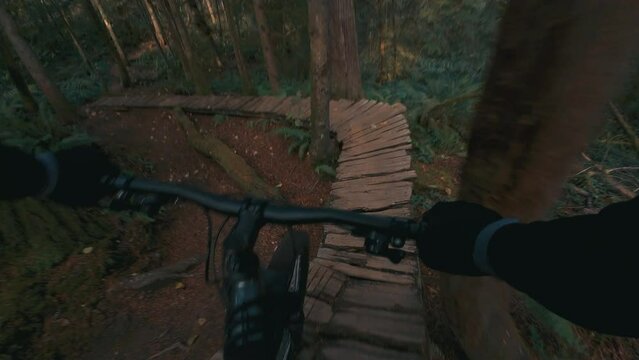 Mountain Biker Balancing Over Winding Wood Ramps