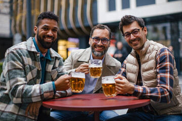 Best friends togehter, drinking beer and talking in bar in city. Concept of male friendship, bromance.