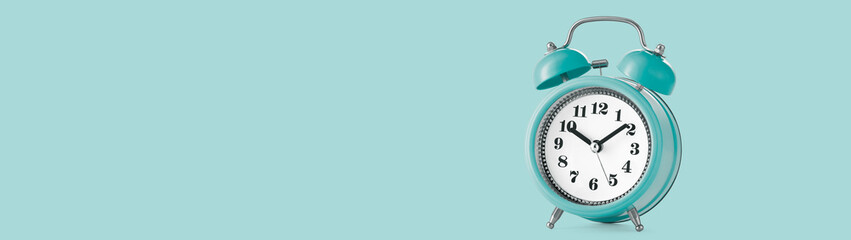 Alarm clock in retro style on a plain background with copy space. Web banner. Low angle view.