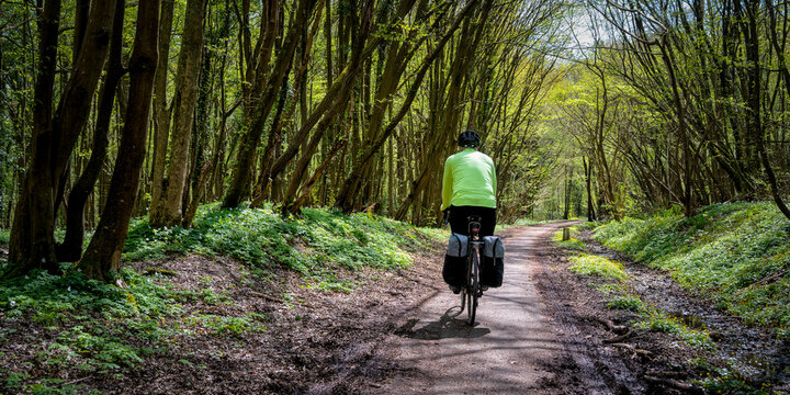 Senior man cycling on dirt road at Cuckoo Trail in East Sussex