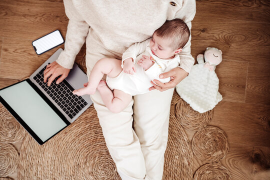Freelancer working on laptop with baby girl sleeping at home