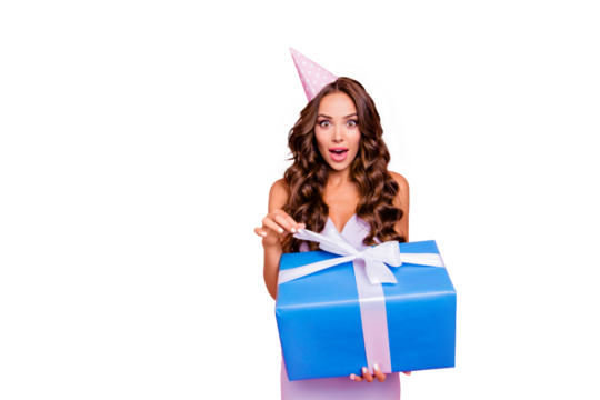 Close up portrait of dreamy, charming, lovely, sweet curly brunette isolated on pastel pink background pool the tie to open blue gift look at camera with open mouth and big eyed copy space