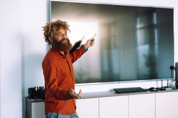 Businessman pointing towards blank screen and giving presentation in office