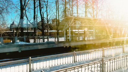 Golden light at railway station in winter. Traveling by train background. Rural railraod flatform in morning sunshine. Soft focus. film grain pixel texture. Defocused.