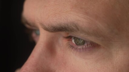 Thinking man eyes and face on black background. Male looking into distance, eyebrows, eyelashes, skin issues macro view