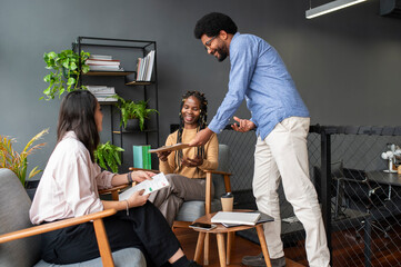 Smiling businessman giving clipboard to colleague in office