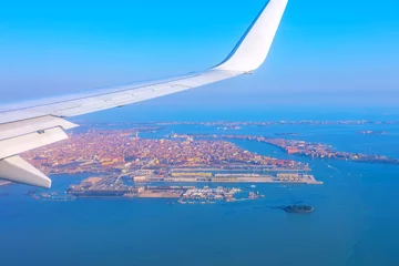 Foto op Plexiglas Plane flying above Venice Italy. View of airplane wing over Venice during taking off or landing.  Aerial view of Venezia and aircraft wing © russieseo