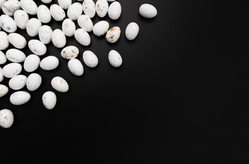 Top view of white easter eggs on black background. Creative easter composition, spring, copy space, flat lay.