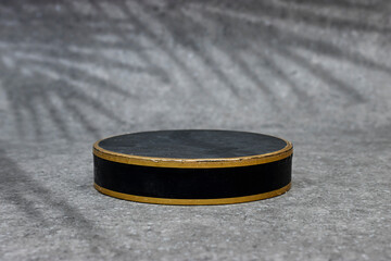 Abstract empty black podium with leaves shadow on grunge gray background. Mock up stand for product presentation. Minimal concept. Advertising template
