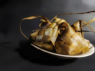 Ripe ketupat available in a plate on a black background
