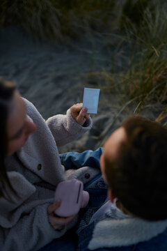 Young couple looking at photographic print developing at beach