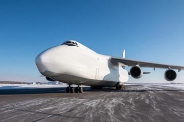White wide body transport cargo aircraft at winter airport