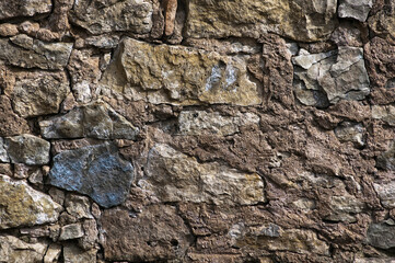 in the photo there is a close-up of an old stone wall