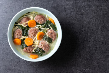 Italian Wedding Soup with meatballs and spinach on black background. Top view. Copy space
