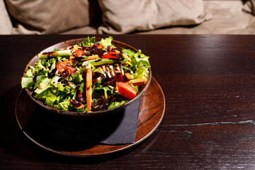 Mixed healthy salat served in wooden plate on background