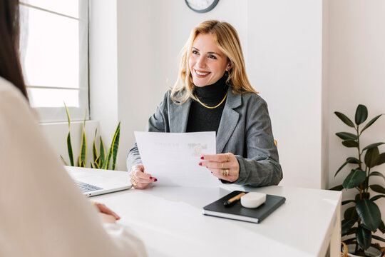 Happy HR manager with resume at desk