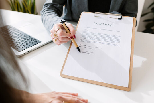 Businesswoman with colleague signing contract in office