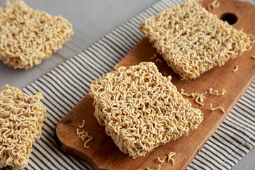 Dry Ramen Noodles on a wooden board, side view.