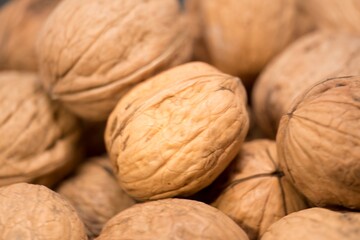 Nature's Bounty: A Close-Up of Fresh, Organic Walnuts, This image features a close-up view of fresh, organic walnuts. Each nut, encased in its shell, showcases intricate textures and rich