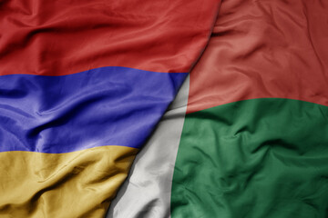 big waving national colorful flag of madagascar and national flag of armenia .