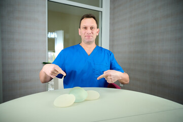 Female plastic surgeon demonstrates breast implants to a patient for her new breast. The plastic...