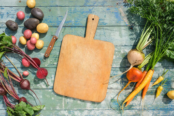 Seasonal vegetables, potatoes, colored carrots, beet, on a wooden background. Top view.