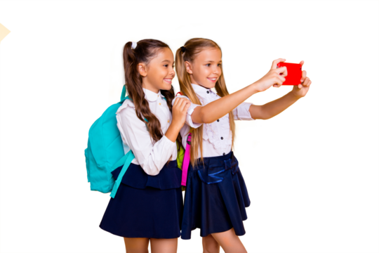 Profile side view photo of two charming, gorgeous, adorable, good-looking small girls make selfie on smartphone camera isolated on shine yellow background