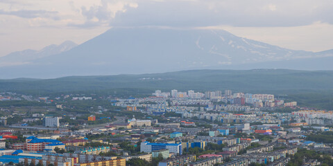 Morning cityscape. Top view of the buildings and streets of the city. Residential urban areas at sunrise. Koryaksky volcano in the distance. Petropavlovsk-Kamchatsky, Kamchatka Krai, Russian Far East.