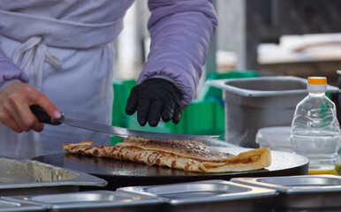 The midsection body of a chef preparing crepes, French pancakes at farmers market stall in Prague...