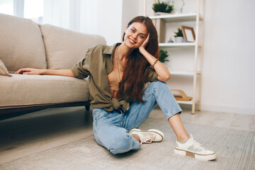 Cosy Home: Woman Smiling and Relaxing on Modern Sofa in Peaceful Living Room.