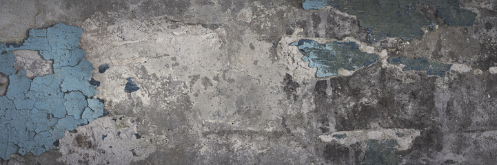 Peeling paint on the wall. Panorama of a concrete wall with old cracked flaking paint. Weathered rough painted surface with patterns of cracks and peeling. Panoramic texture for background and design.