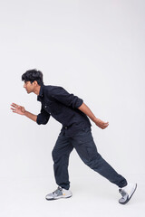 Side view of an athletic young Indian man focused and poised to start a sprint on a clean background, capturing energy and agility.