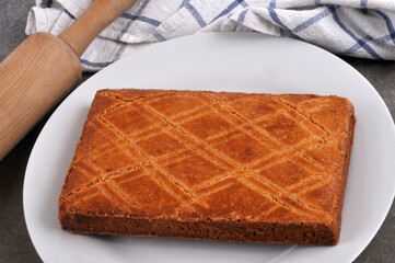 Gâteau traditionnel breton dans une assiette avec un rouleau à pâtisserie et un torchon en gros plan