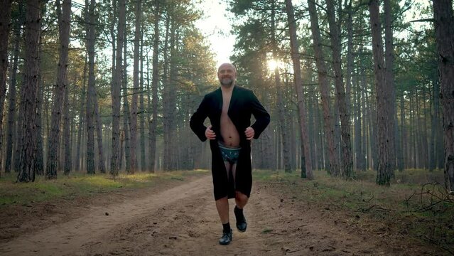 Sexually unhealthy man opens his coat in forest displaying his underwear. Exhibitionist demands attention. Psychological disorders, sexual upbringing issues, emotional disturbances, depression