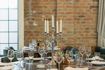 Candles on a candlestick burning on a restaurant table