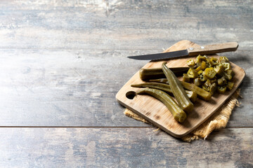 Natural Okra slices on cutting board on wooden table. Copy space