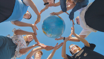 Students make a circle around the globe of the world. The concept of world peace. - obrazy, fototapety, plakaty