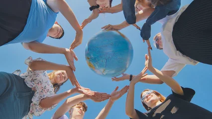 Foto op Plexiglas Students make a circle around the globe of the world. The concept of world peace. © Довидович Михаил