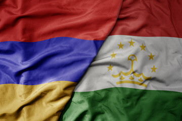 big waving national colorful flag of tajikistan and national flag of armenia .