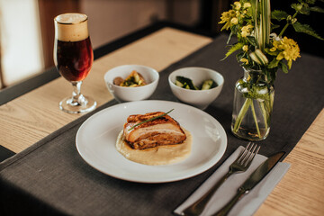 seared pork belly with glass of beer on table