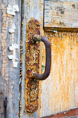 Rusty metal door handle close-up, vertical photo.