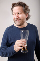 nordic man looking to the side with glass of beer in hand