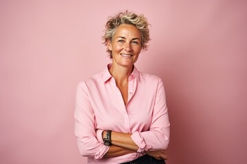 Portrait of smiling mature woman in pink shirt on pink background. - Powered by Adobe