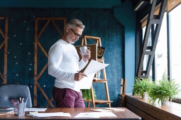 Serious pensive thoughtful focused middle-aged casual entrepreneur accountant bookkeeper in office...
