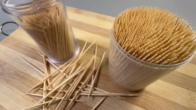 Wood toothpicks in plastic containers and scattered beside, selective focus