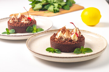 Delicious chocolate tart garnish with cherry and mint. Classic dessert. - 745728564