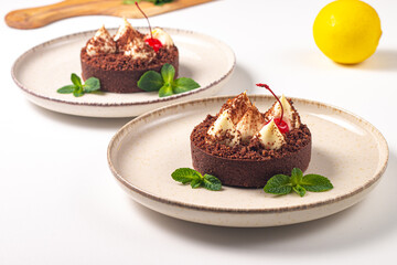 Delicious chocolate tart garnish with cherry and mint. Classic dessert. - 745728572