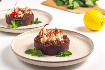 Delicious chocolate tart garnish with cherry and mint. Classic dessert. - 745728574